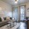 Spacious and well lit living room with wood flooring, large windows and open access to the kitchen