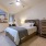 Large well lit bedroom with plush carpets and large windows 