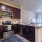 Spacious and well lit kitchen with stainless steel appliances and dark accents 