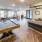 Spacious and well lit game room with billiard tables and plenty of seating.